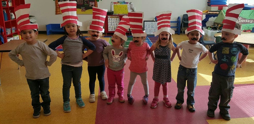 Group of children wearing striped hats and fake mustaches
