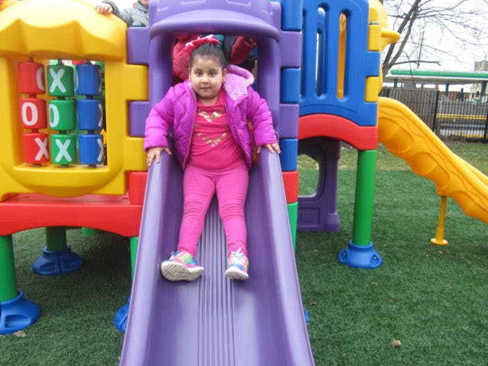 Child on a purple slide at a playground
