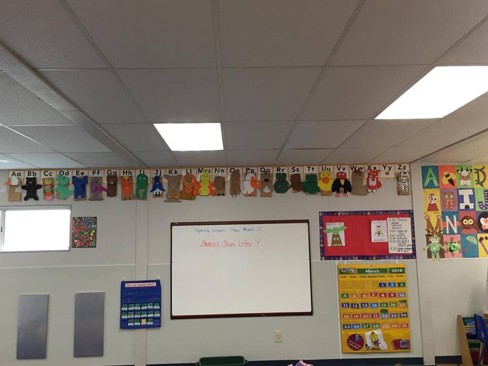 Classroom wall with a whiteboard, bulletin board, and student artwork
