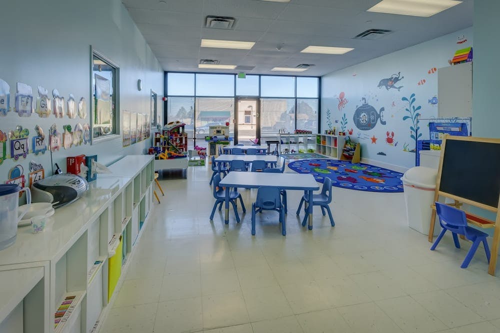 Empty classroom with small tables and chairs