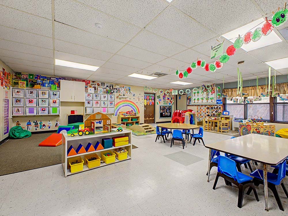 Empty classroom with children's toys, tables, and decorations