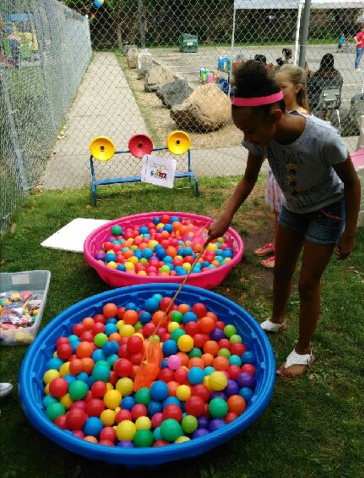 Child playing a fishing game in a ball pit