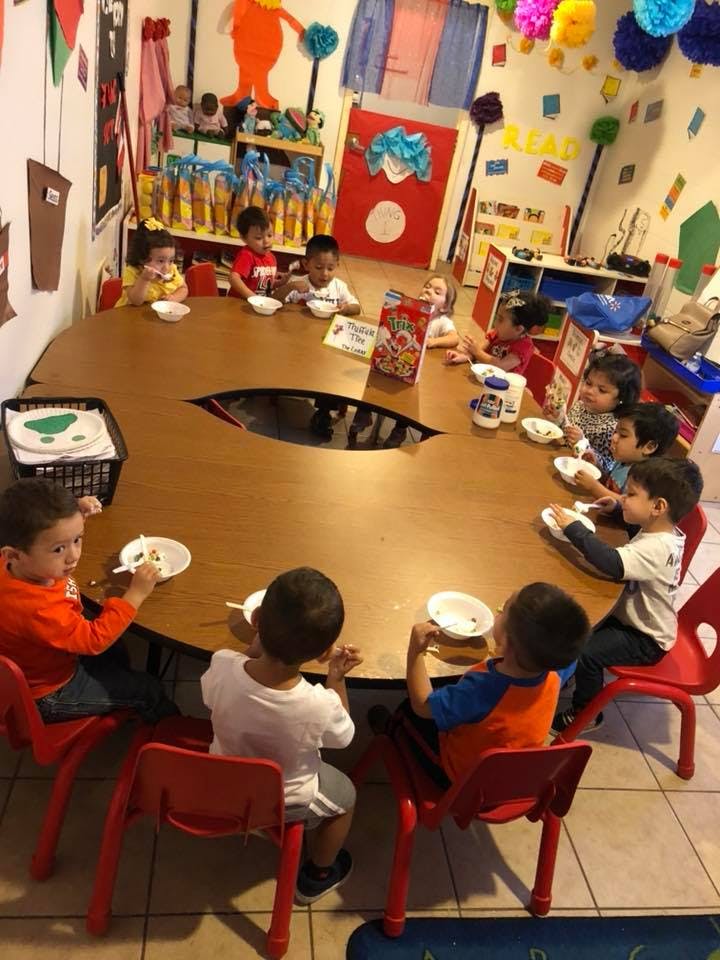 Children sitting around a large table in a classroom