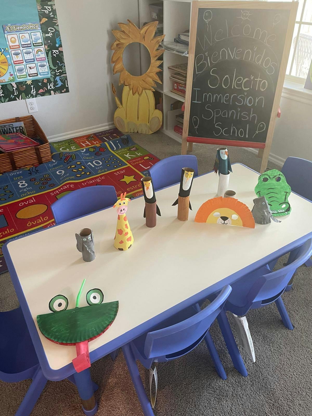 Classroom with a table and chairs, animal crafts, and a chalkboard