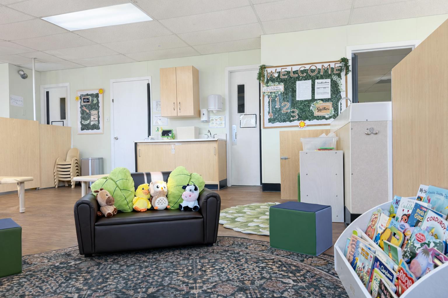Small couch with plush animal toys in a classroom with a book display