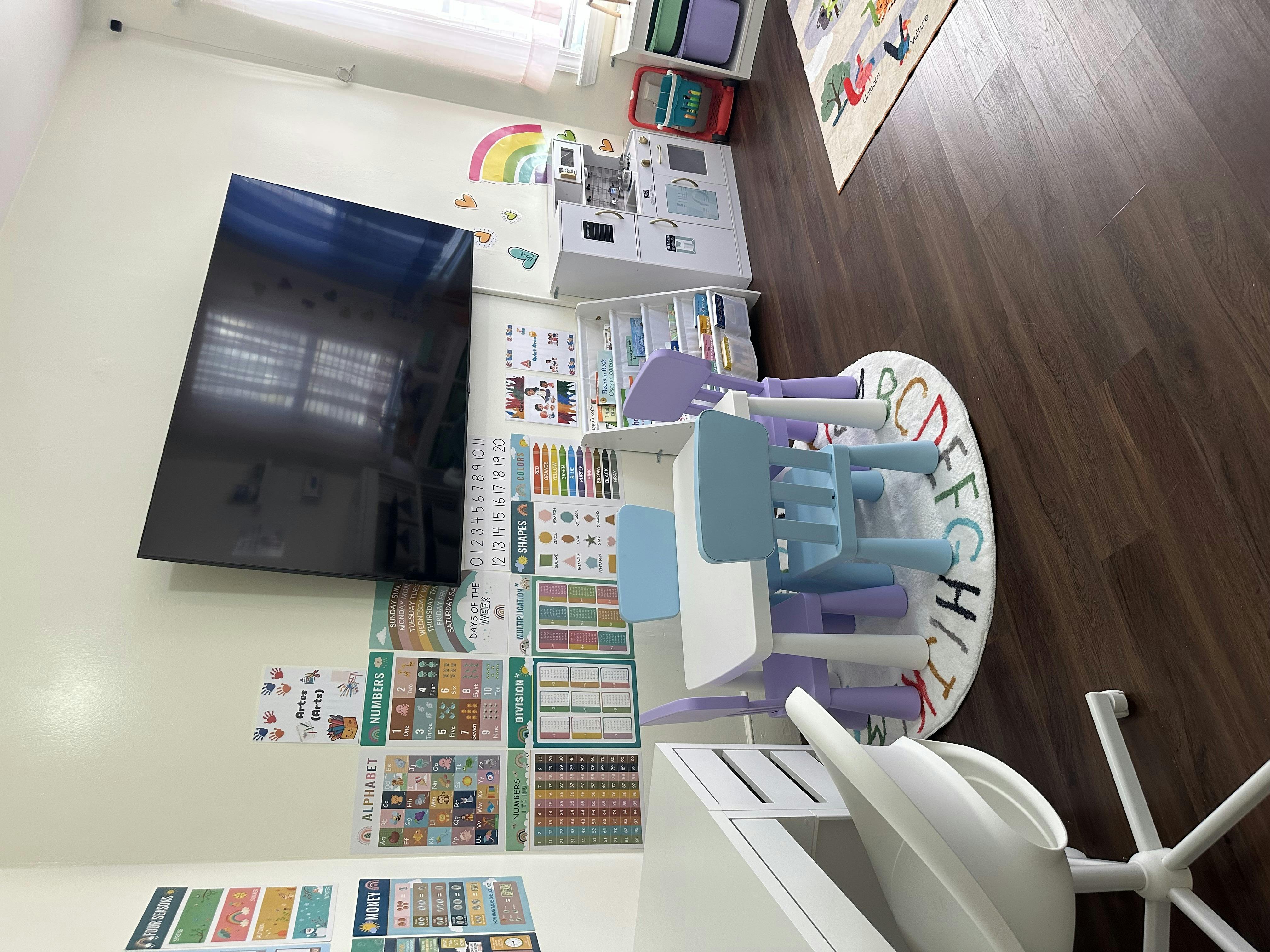 Children's play area with a television, shelves, and small table and chairs