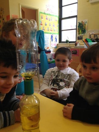 Children watching a science experiment with bottles inverting bottles