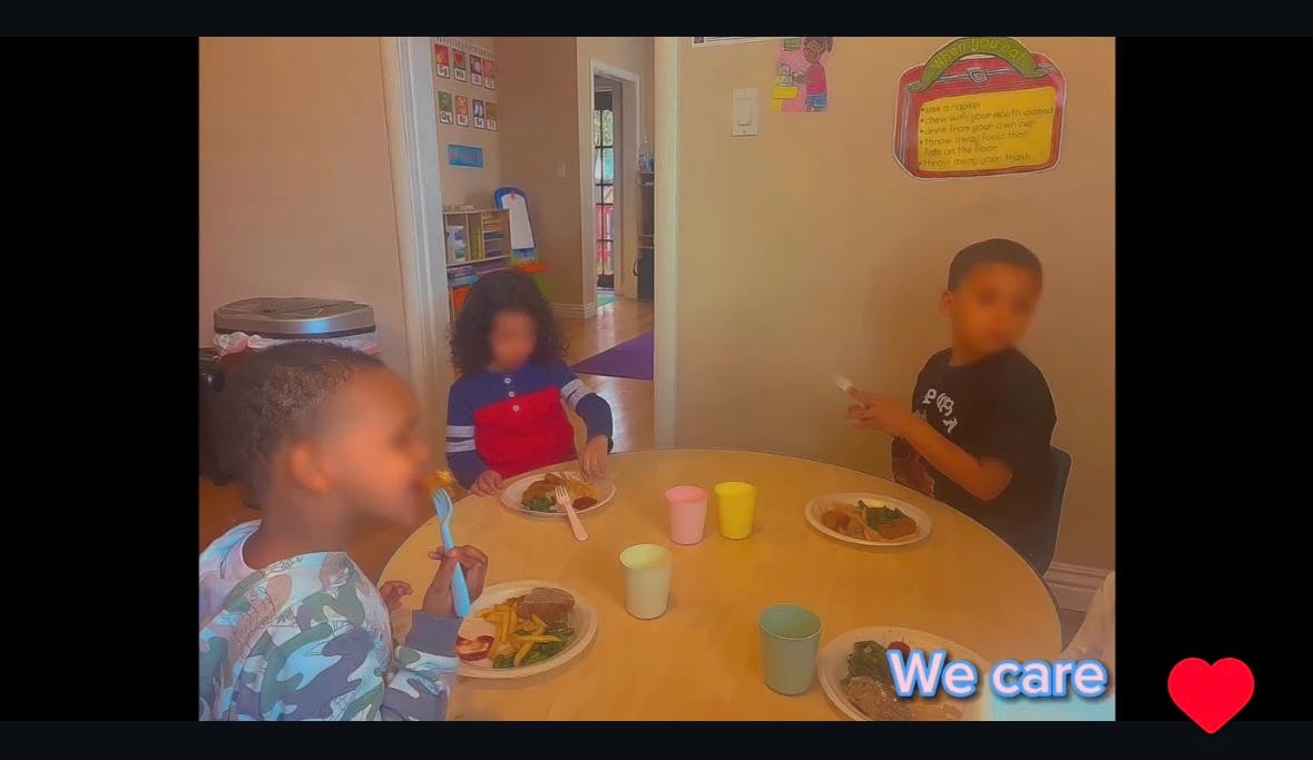 Three children sitting around a table with plates of food