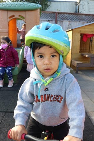 Child in a blue helmet on a bike
