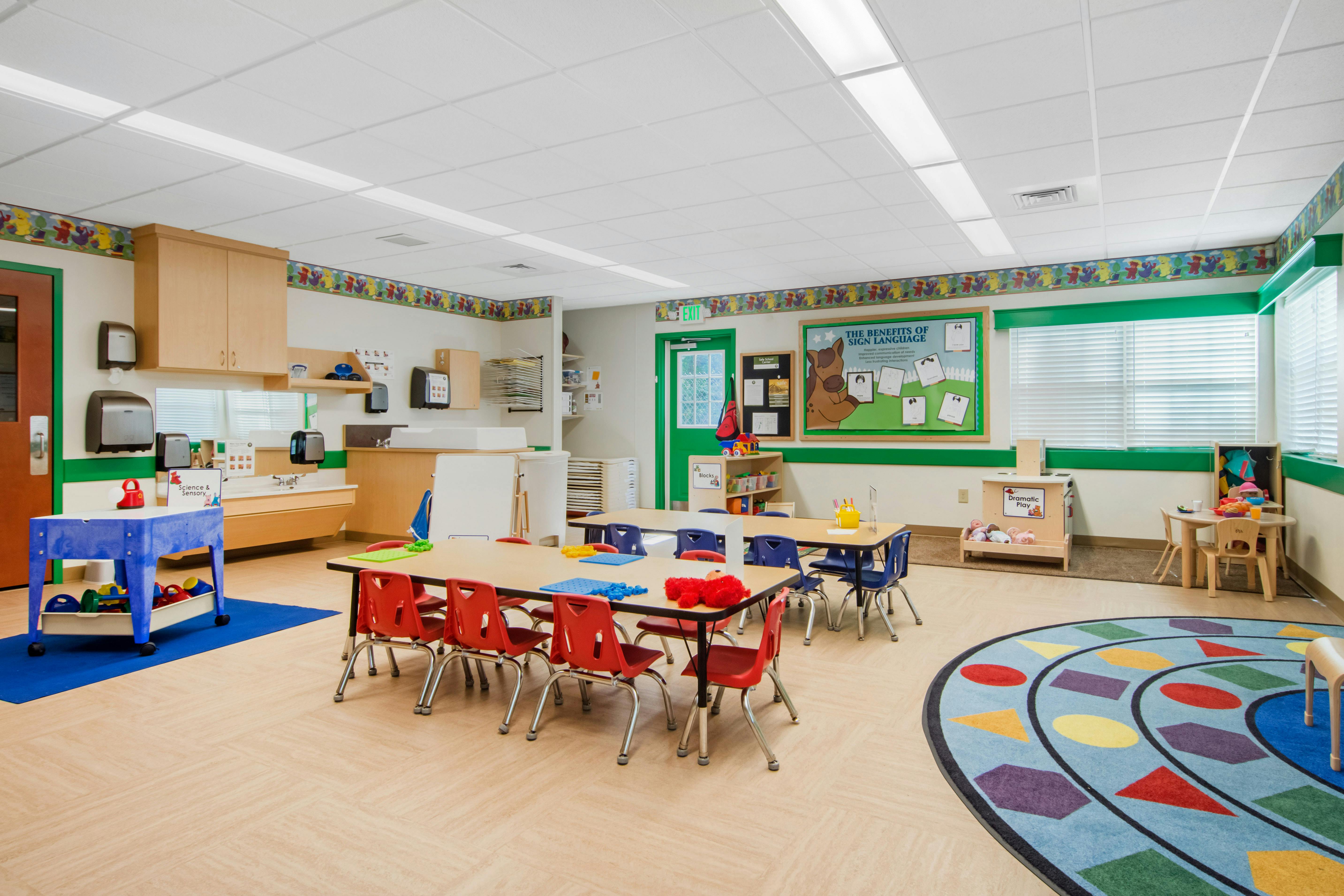 A colorful empty classroom with small tables and chairs