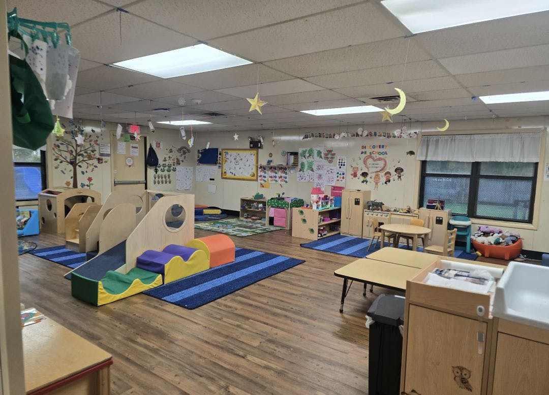 Childcare classroom with play structures, tables, and toys