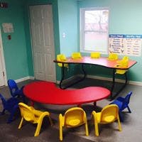 Classroom with red and yellow tables and blue and yellow chairs