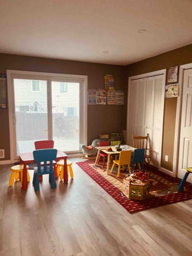 Playroom with small tables and chairs, and a red rug