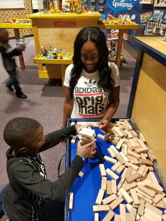 Person and child playing with wooden blocks