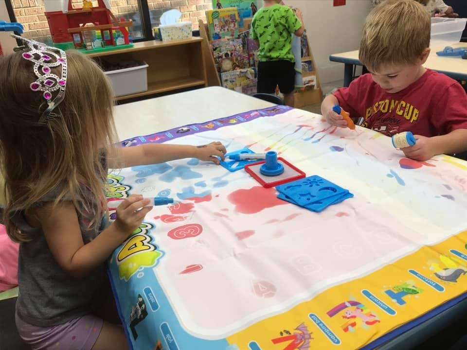 Two children painting at a table