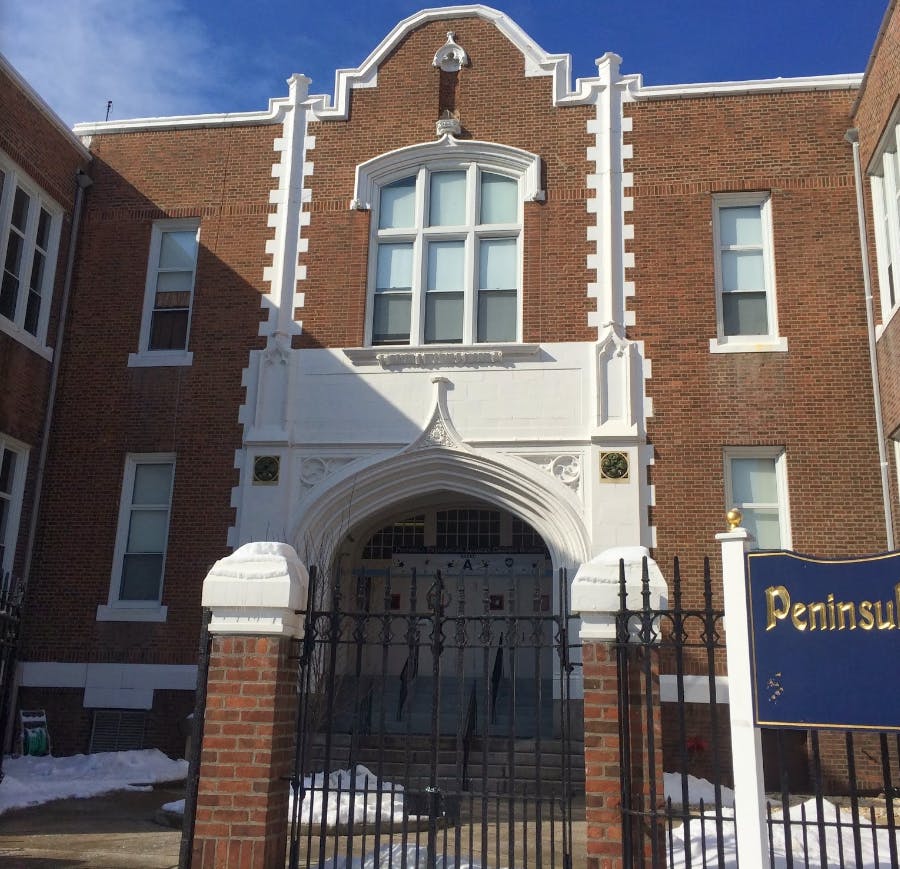 Brick building with white architectural details and an arched entrance