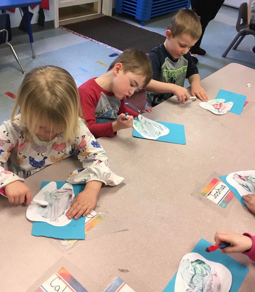 Three children doing an art project at a table