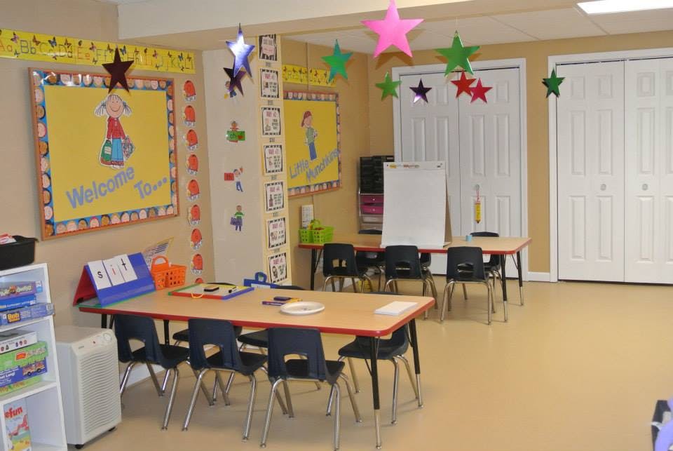Classroom with tables and chairs, decorated with stars and bulletin boards