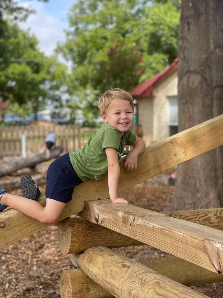 Child climbing on wooden playground structure