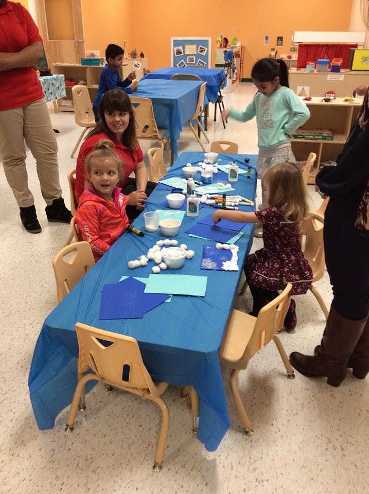 Adult and children at a table with craft supplies
