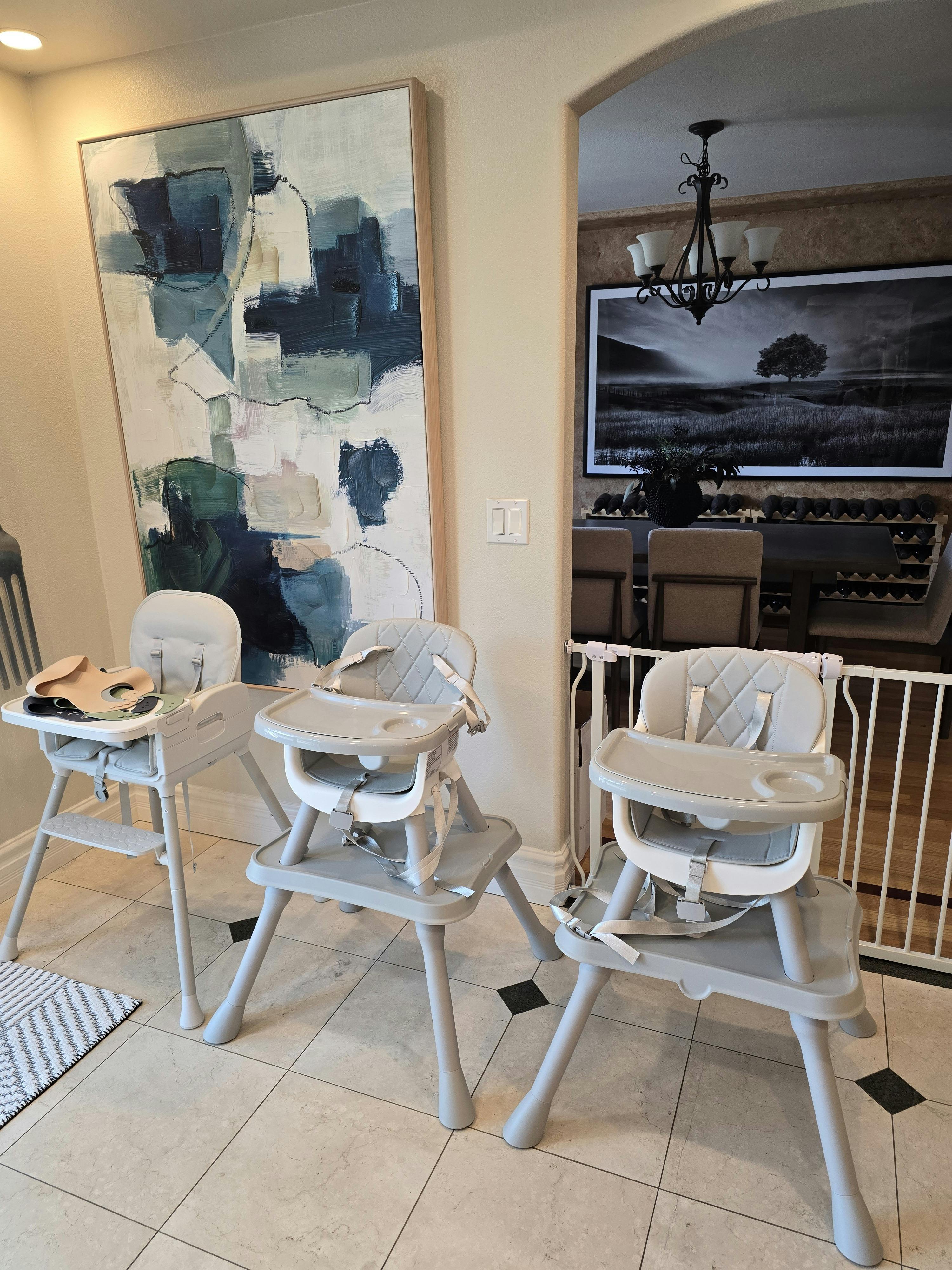Three high chairs lined up in a home dining area