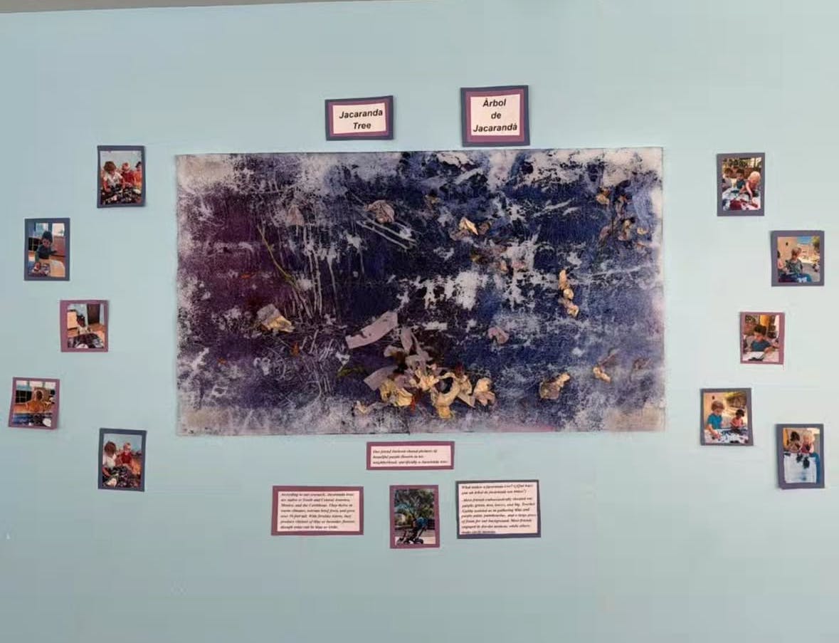 Wall display with a large abstract painting surrounded by smaller framed photos