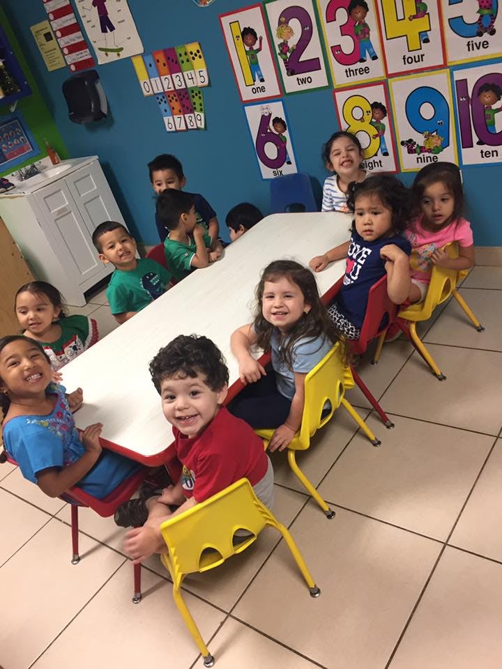 Children sitting at a table in a classroom