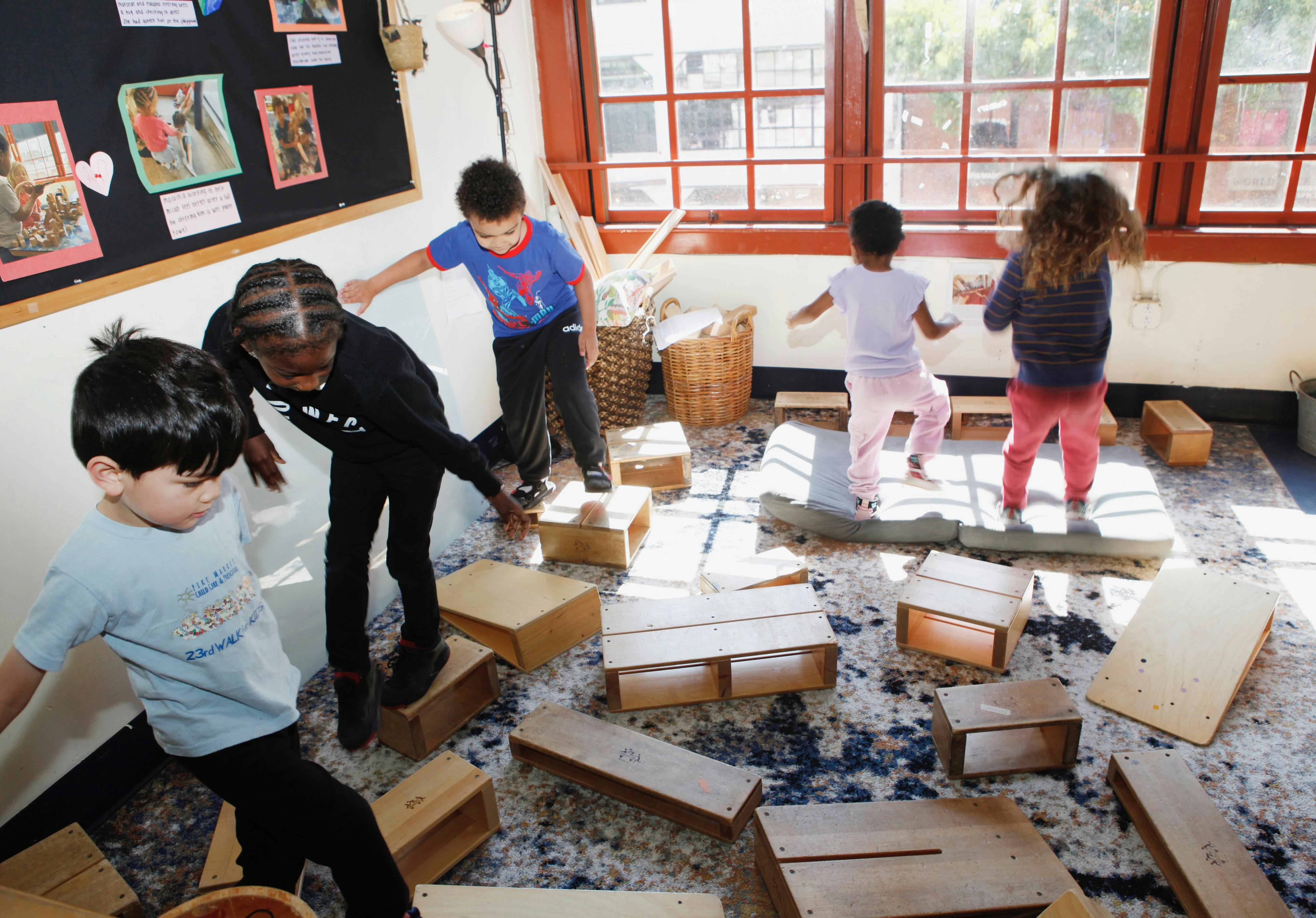 Children playing with wooden blocks in a classroom