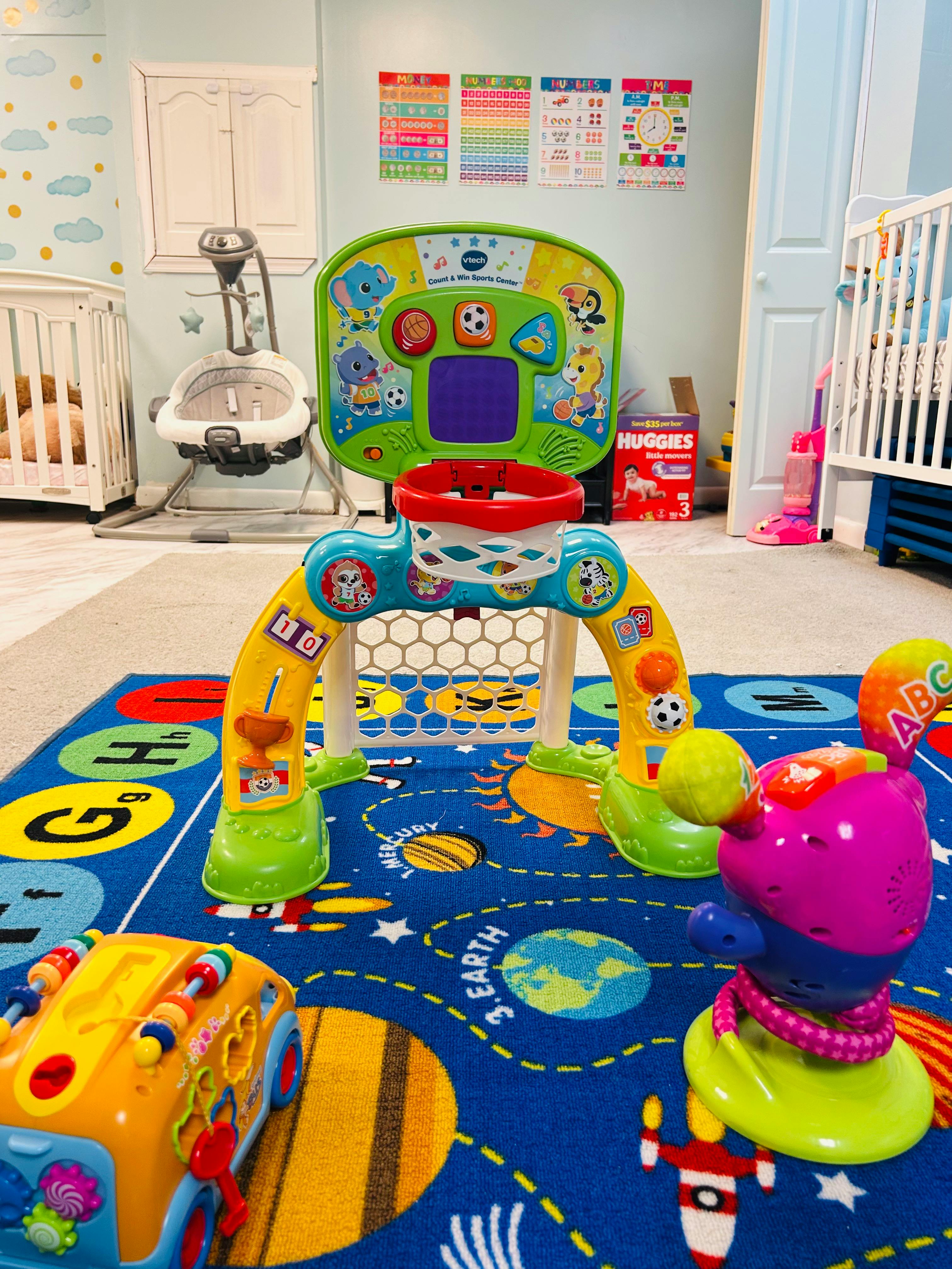 Colorful toy basketball hoop and soccer goal on a planet themed rug