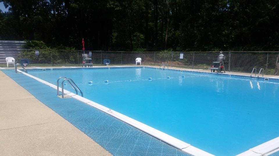 Empty outdoor swimming pool with lane lines and ladders