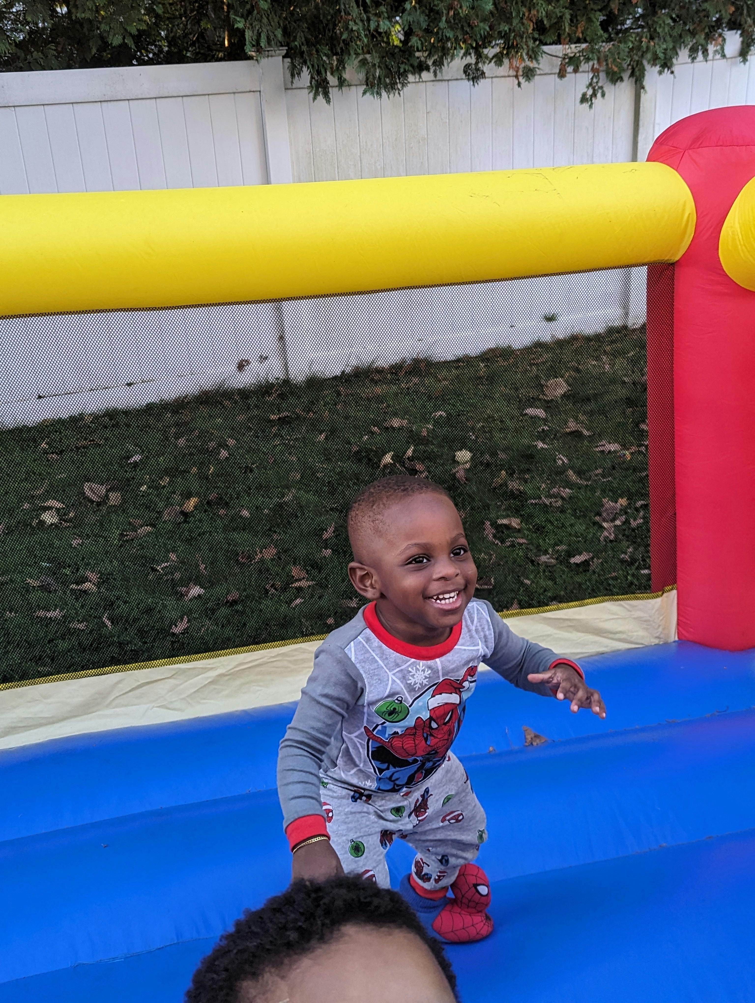 Child in pajamas on a blue inflatable