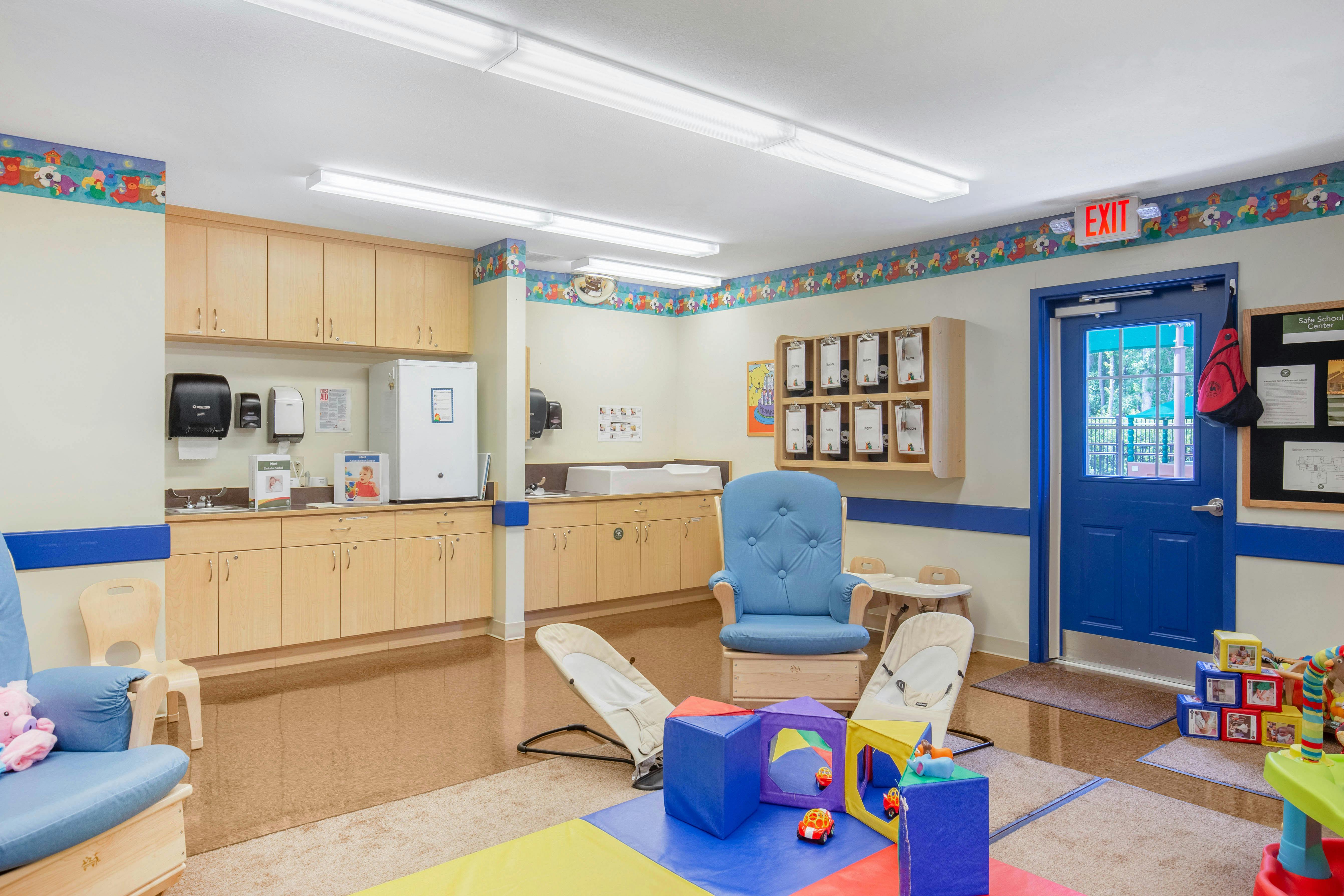 Classroom with diaper changing station, storage, infant rockers, and play mat