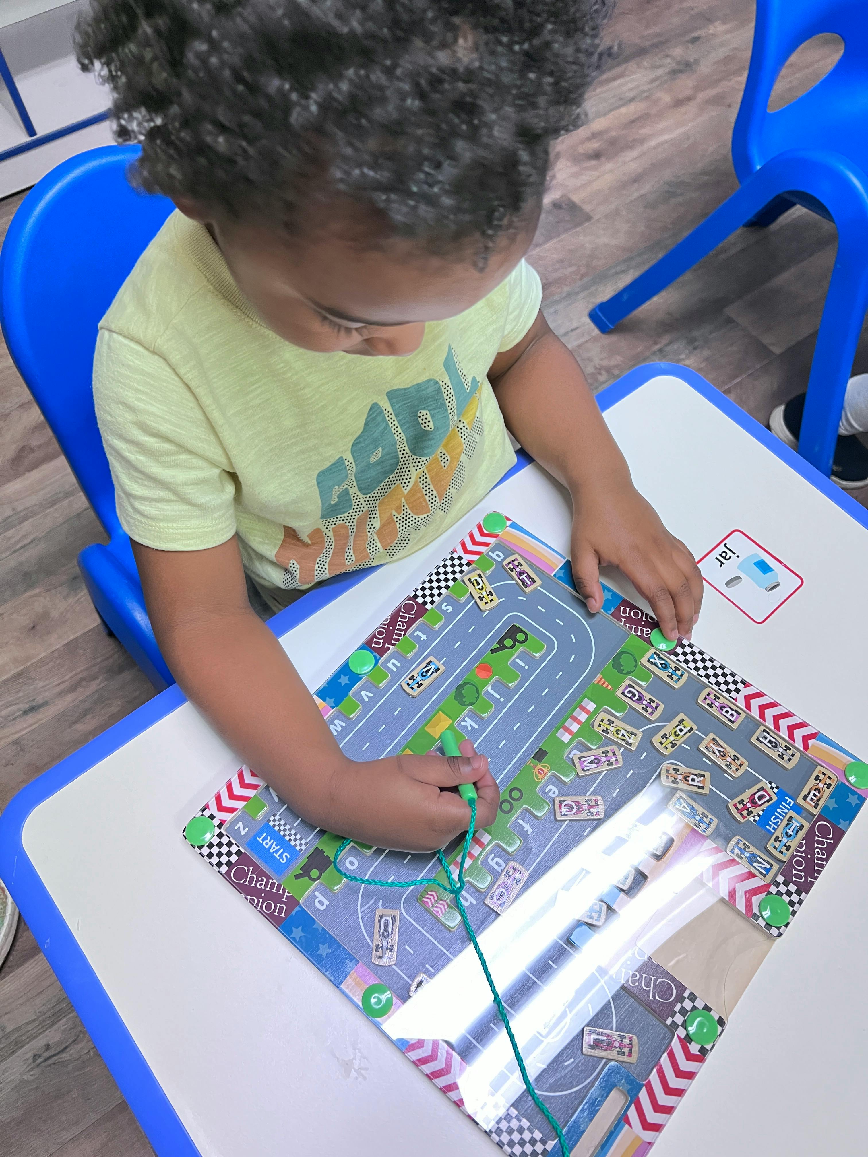 Child playing with a lacing activity on a table