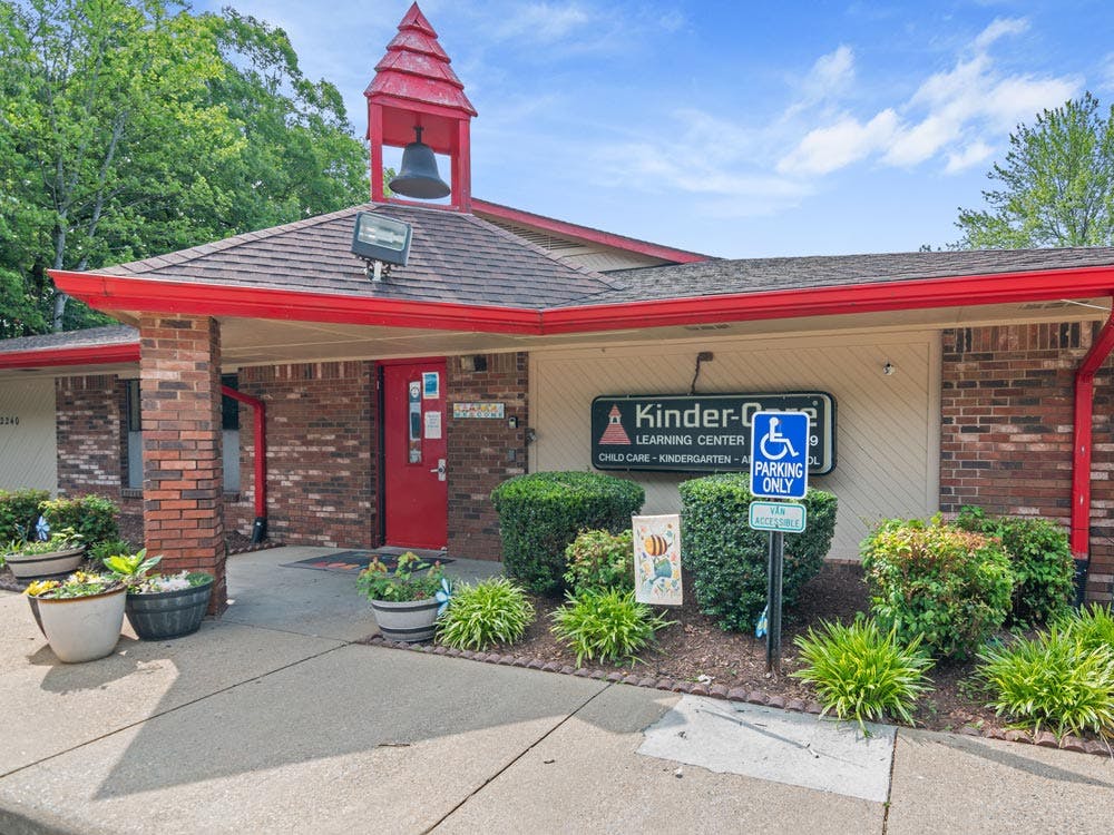 Kinder-Care Learning Center entrance with a red door and a bell tower
