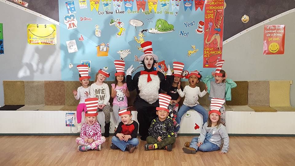 Person in Cat in the Hat costume with children wearing striped hats