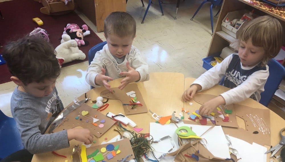 Three children doing crafts at a table