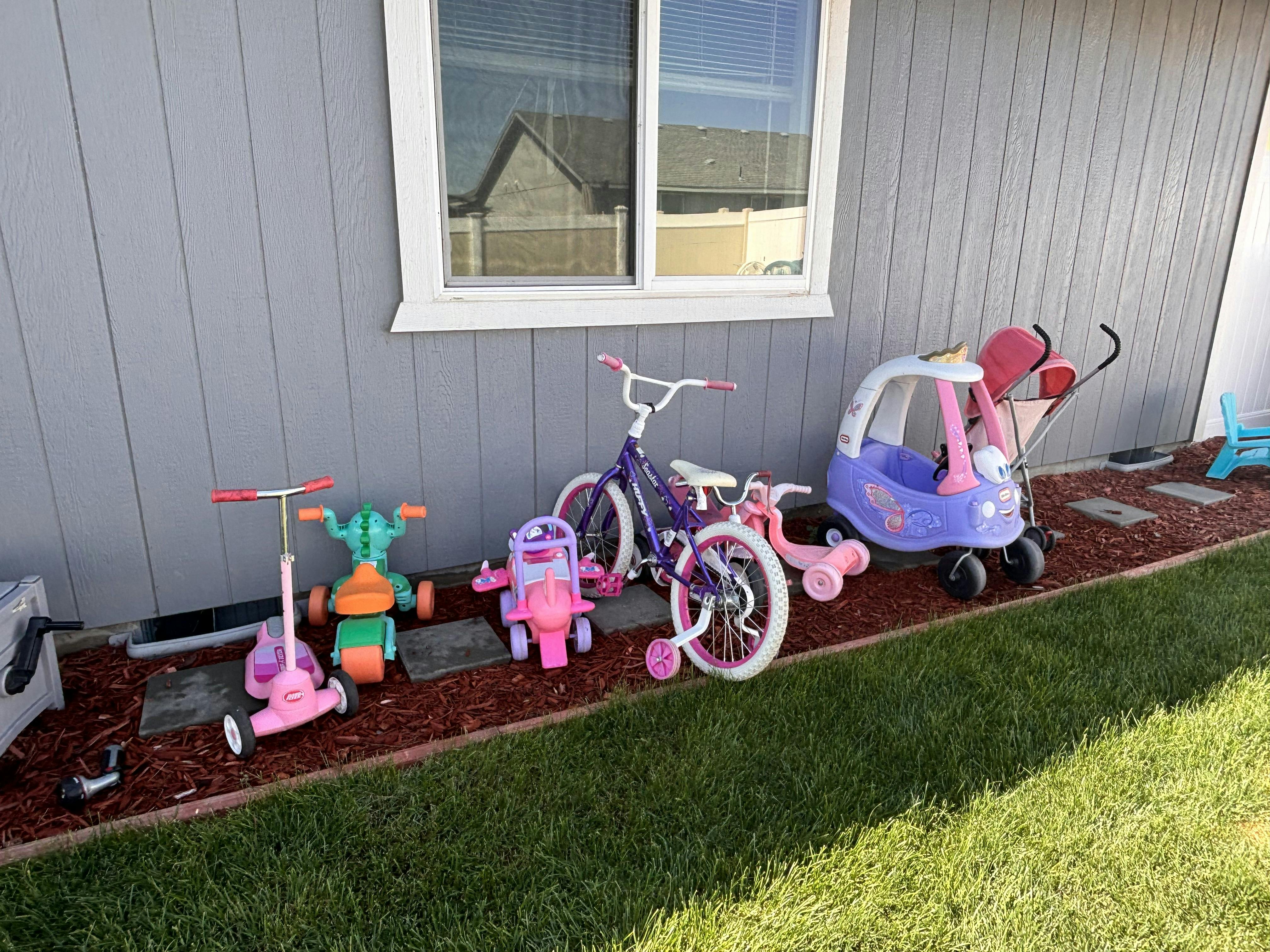 Children's toys including scooters, tricycles, and a small car