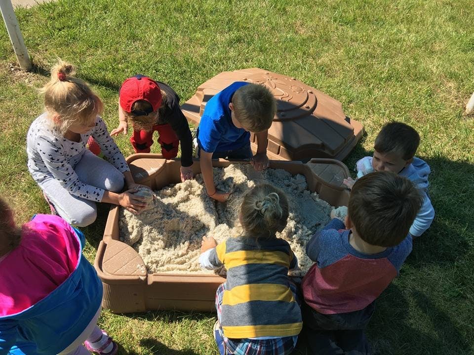 Children playing in a sandbox outdoors