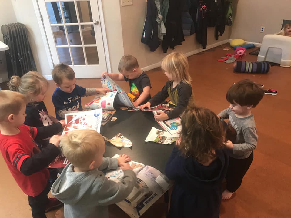 Group of children gathered around a table with papers