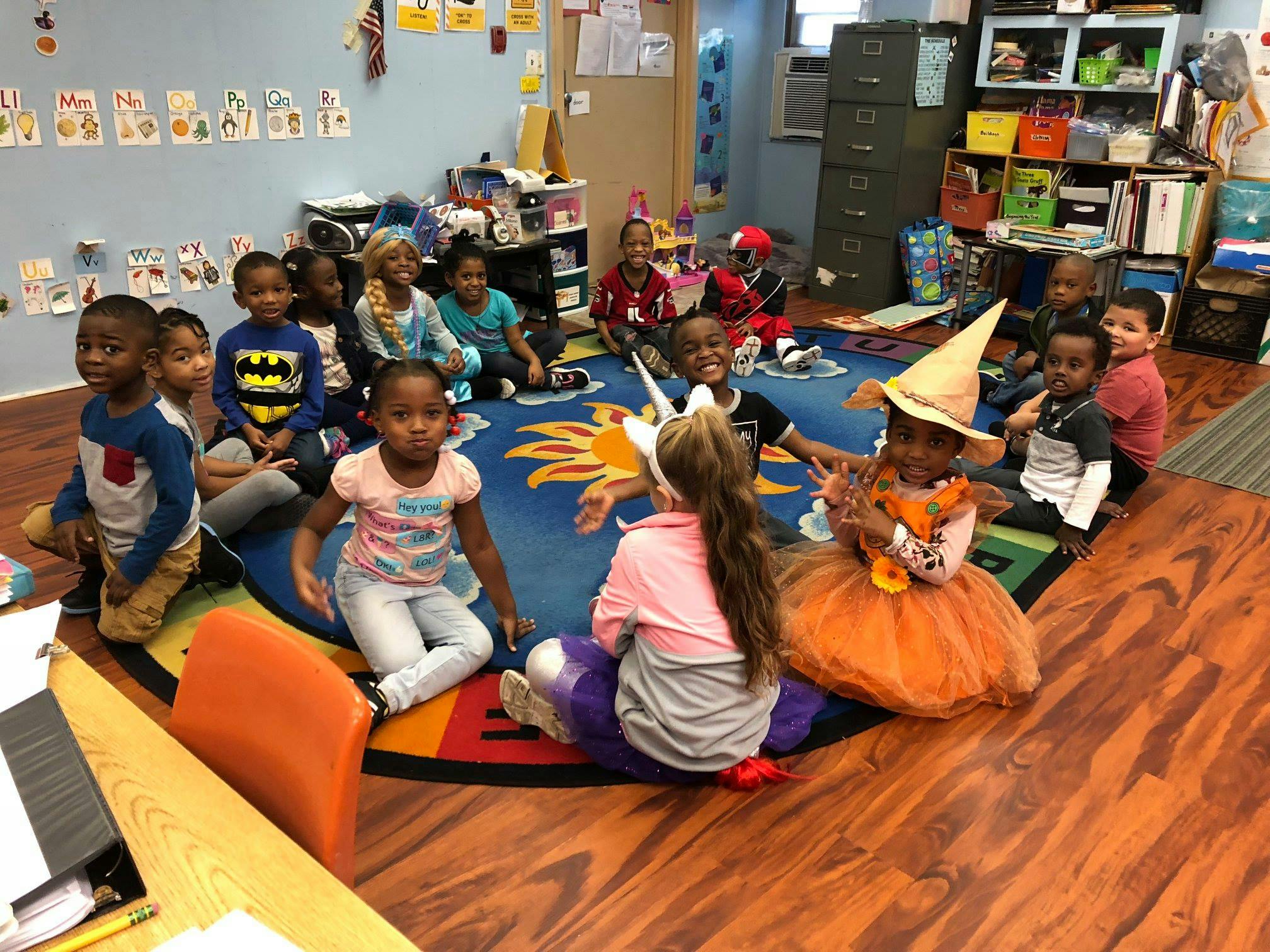 Children sitting on a rug in a classroom