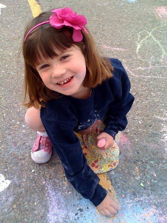 Child drawing with chalk on the ground