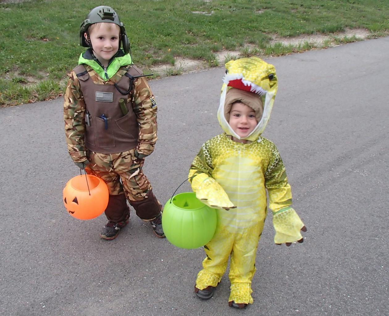 Two children in costumes holding trick-or-treat buckets