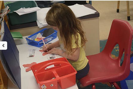 Child sitting at a desk and drawing