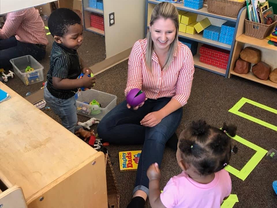 Adult and two children playing on the floor