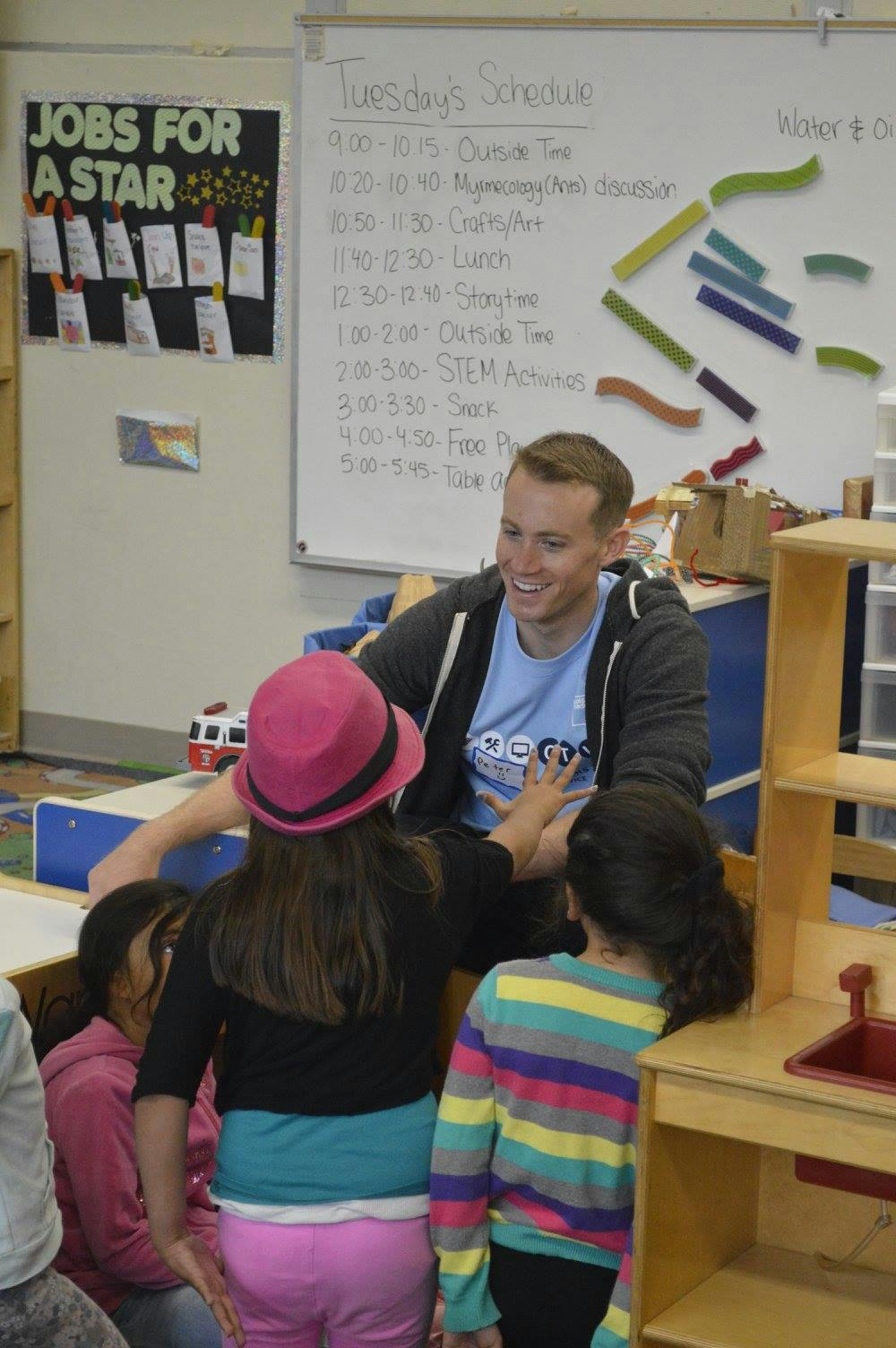 Adult person interacting with children in a classroom