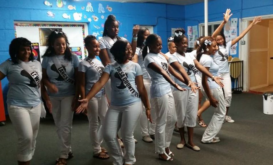 Group of teens in matching shirts and pants posing