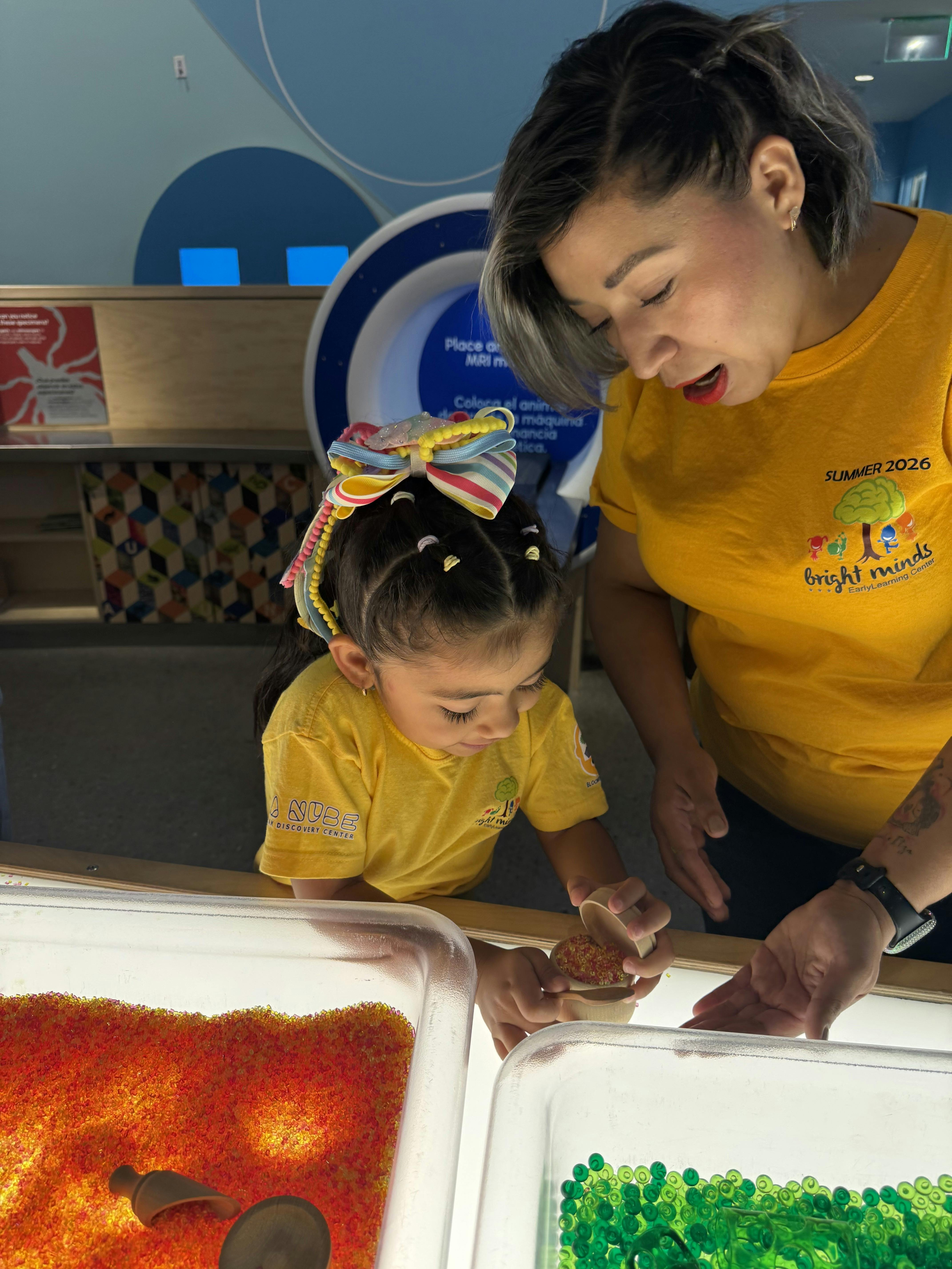 Adult and child playing with sensory beads at a learning center