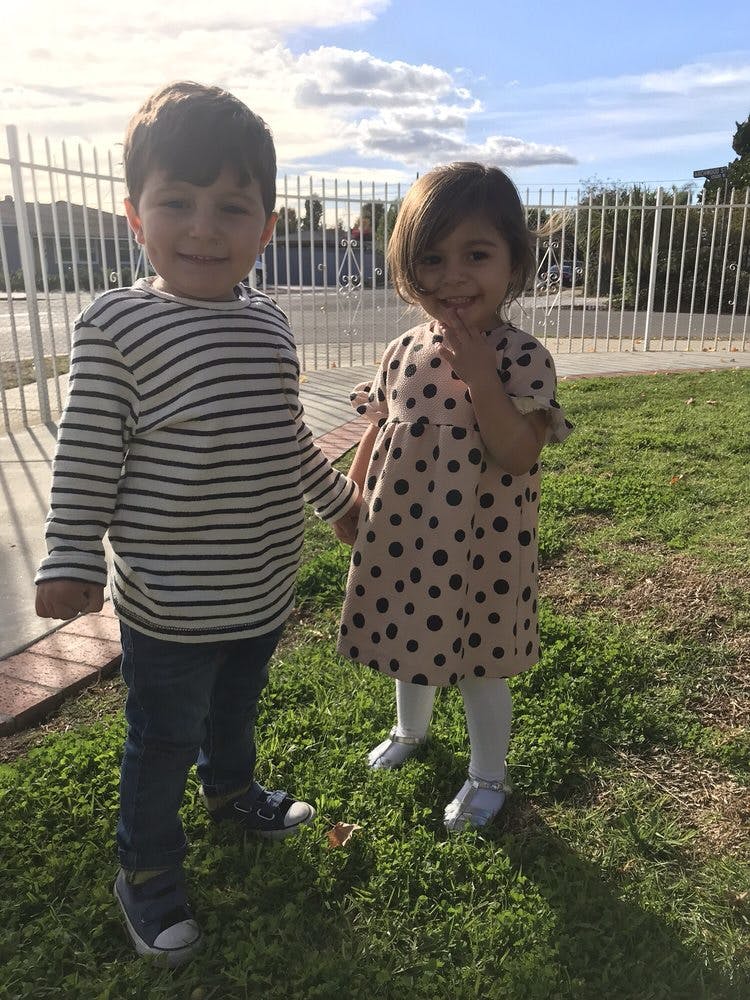Two children standing on grass