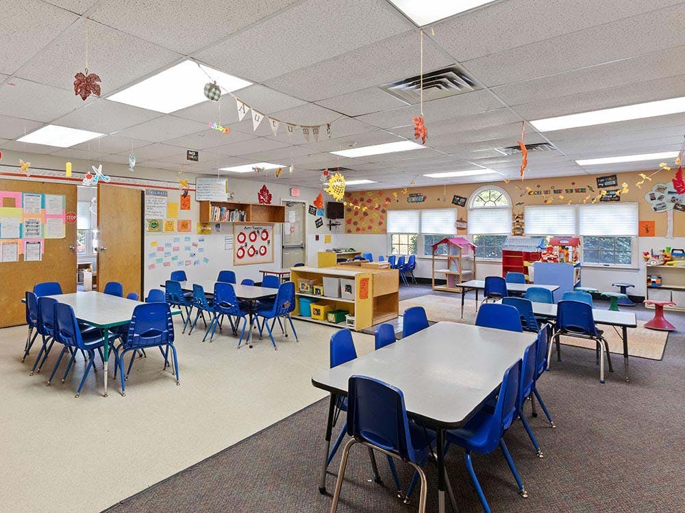 Empty classroom with small blue chairs and tables