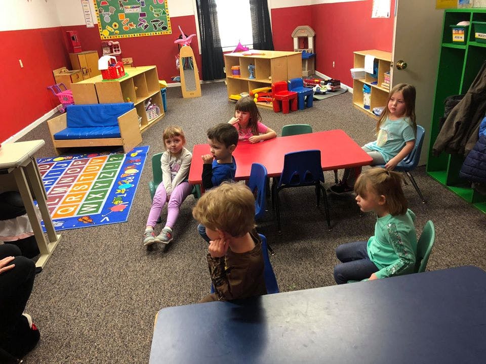 Children sitting at tables in a classroom